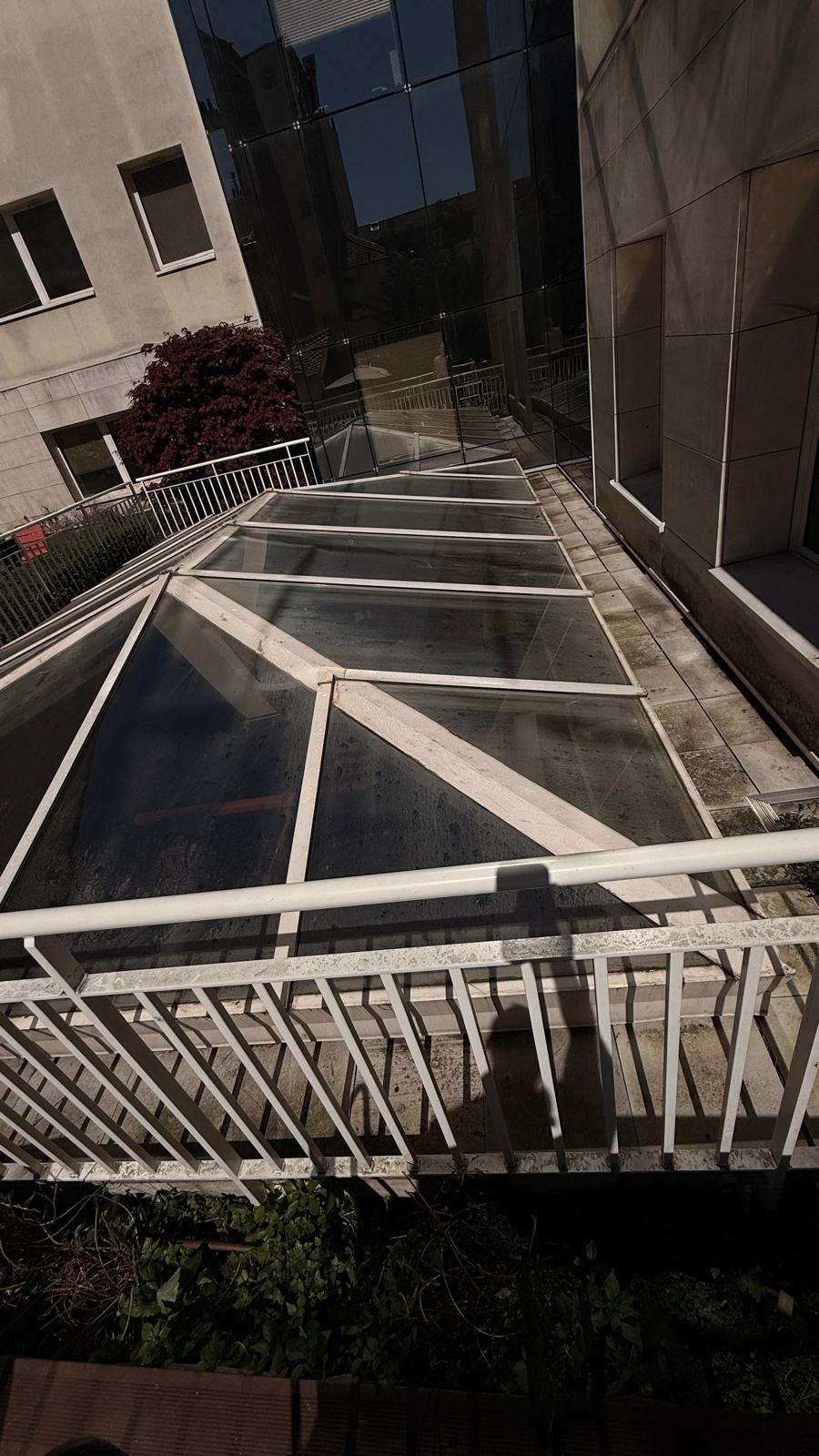 Toiture vitrée d'immeuble à nettoyer, accès en hauteur depuis coursive